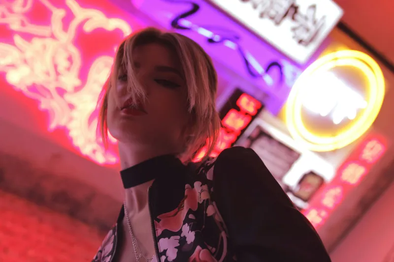 A figure in a neon-lit city at night